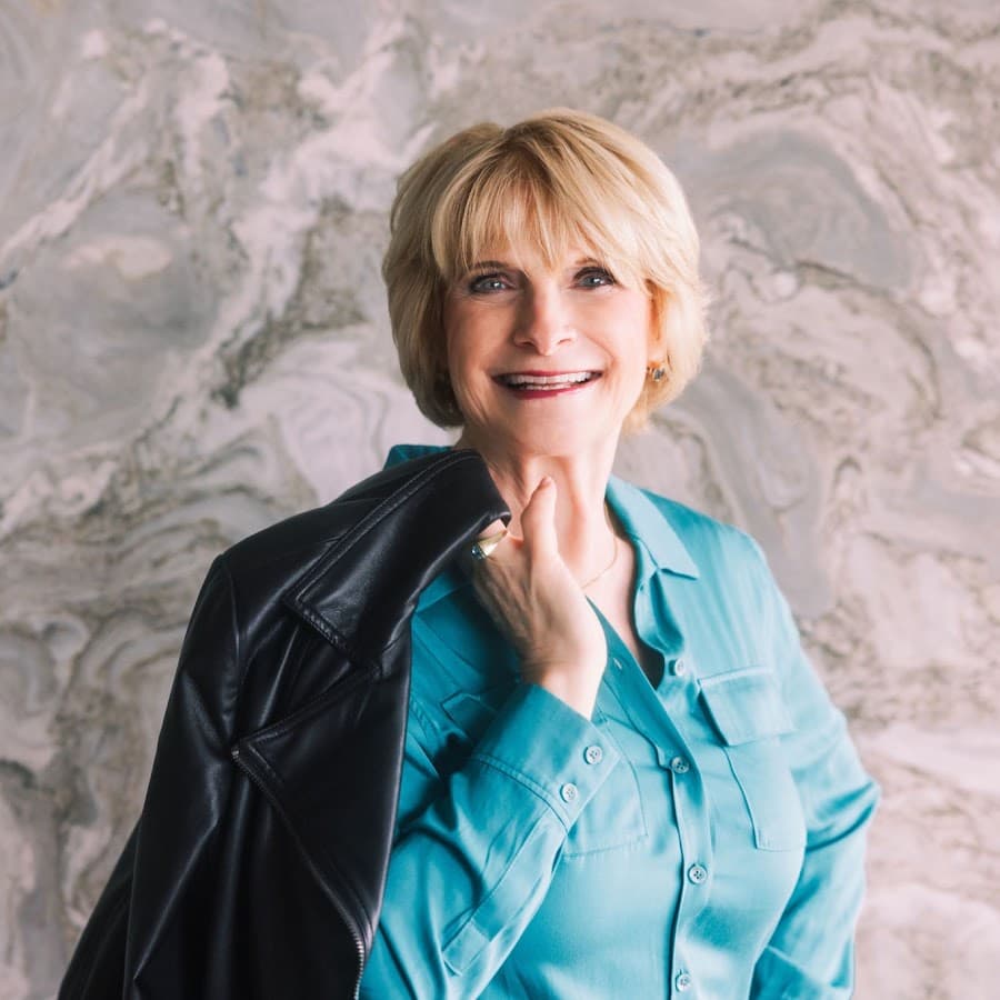 Ral West, smiling, a leather jacket over her shoulder