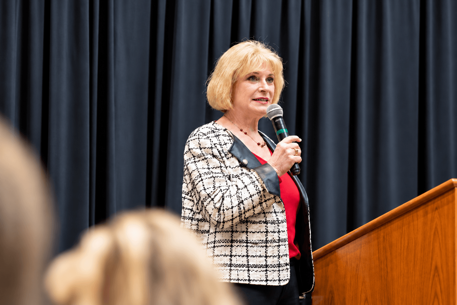 Ral West speaking to a room, microphone in hand